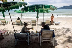 Du khách trên bãi biển ở Phuket, Thái Lan, ngày 14/8/2021. (Ảnh: AFP/TTXVN)