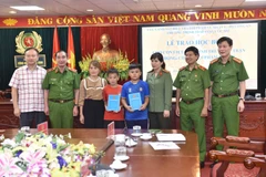 Thiếu tướng Trần Văn Doanh và Thiếu tướng Vũ Hùng Vương cùng Công an tỉnh Hòa Bình trao học bổng tặng cháu Đỗ Nguyễn Minh Đăng, cháu Sùng Hà Sơn. (Nguồn: Cand.vn)