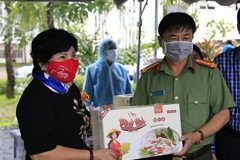 Bà Lê Thị Giàu, Chủ tịch Hội đồng quản trị Công ty Cổ phần Thực phẩm Bình Tây trao quà cho lực lượng làm nhiệm vụ tại khu cách ly tập trung tại Trường Đại học An Giang. (Ảnh: Thanh Sang/TTXVN)