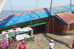 Tàu Hoàng Phúc 18 được nâng lên cao và lật lại bình thường vào lúc 14 giờ ngày 3/11. (Ảnh: TTXVN Phát)