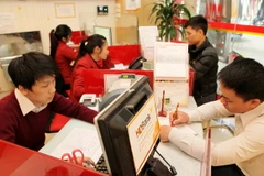 Khách hàng giao dịch tại HDBank Tràng Tiền (Hà Nội). (Ảnh: Trần Việt/TTXVN)