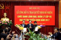 Bộ trưởng Lê Vĩnh Tân tặng hoa chúc mừng ông Trần Trung Kiên và bà Phạm Thu Hằng. (Nguồn: Bộ Nội vụ)