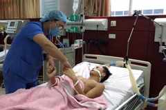 Bác sỹ tại Bệnh viện Đa khoa tỉnh Bắc Ninh thăm khám cho bệnh nhân Nguyễn Đức Khải. (Ảnh: Thanh Thương/TTXVN)