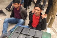 Hai đối tượng Võ Văn Ân, Lê Văn Hùng và tang vật vụ án. (Ảnh: Thái Hùng/TTXVN)