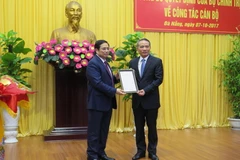 Ông Phạm Minh Chính, Ủy viên Bộ Chính trị, Trưởng Ban Tổ chức Trung ương trao quyết định cho ông Trương Quang Nghĩa. (Ảnh: Văn Sơn/TTXVN)