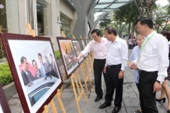 Bộ trưởng Bộ Thông tin và Truyền thông Trương Minh Tuấn và cán bộ, phóng viên TTXVN tham quan trưng bày ảnh Tuần lễ Cấp cao APEC 2017. (Ảnh: Doãn Tấn/TTXVN)