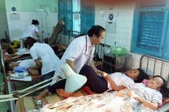  Các bác sỹ tập trung cấp cứu cho các học sinh bị ngộ độc thực phẩm. (Ảnh: Công Thử/TTXVN)