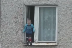 [Video] Thót tim em bé nghịch ngợm treo mình ngoài cửa sổ tầng 8