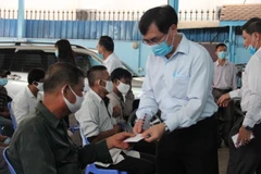 Công sứ Đại sứ quán Việt Nam tại Campuchia Lại Xuân Chiến trao quà hỗ trợ cho bà con tại chương trình hỗ trợ khẩn cấp đợt 2. (Ảnh: Nguyễn Hoàng/Vietnam+)