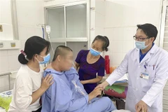 Bác sỹ kiểm tra tình trạng bệnh nhân sau hơn 20 ngày điều trị. (Ảnh: TTXVN phát)