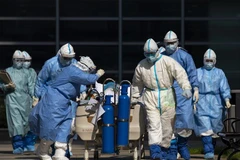 Nhân viên y tế chuyển bệnh nhân mắc COVID-19 tới phòng điều trị tích cực tại một bệnh viện ở Vũ Hán, Trung Quốc. (Ảnh: THX/TTXVN)