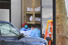 Nhân viên y tế chuyển thi thể bệnh nhân COVID-19 từ một nhà xác dã chiến tới Trung tâm y tế Do thái Kingsbrook ở Brooklyn, New York, Mỹ. (Ảnh: AFP/TTXVN)