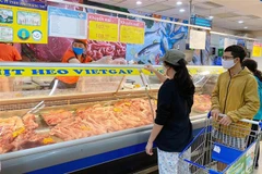 Người tiêu dùng mua thịt lợn tại Co.opmart. (Ảnh: TTXVN phát)
