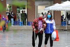 Người nghèo, người có hoàn cảnh khó khăn bị ảnh hưởng bởi dịch COVID-19 nhận quà trong sáng 25/4. (Ảnh: Thanh Tùng/TTXVN)