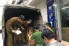 Cơ quan chức năng kiểm tra, thu giữ số hàng hóa không rõ chứng từ, nguồn gốc xuất xứ tại Công ty Đức Anh. (Ảnh: TTXVN phát)