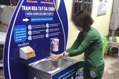 Người dân rửa tay tại trạm rửa tay dã chiến. (Ảnh: TTXVN)