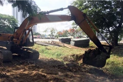 Các nhà thầu thi công triển khai mở rộng đường tạm. (Ảnh: Tiến Lực/TTXVN)