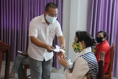 Ông Võ Tuấn Ngọc, Lãnh đạo Tổ Công tác cộng đồng Đại sứ quán Việt Nam, trao hàng cứu trợ cho bà con gốc Việt tại Campuchia. (Ảnh: TTXVN/phát)