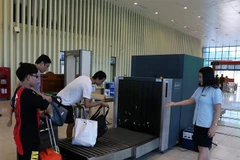 Nhân viên Chi cục Hải quan cửa khẩu quốc tế Hữu Nghị (Lạng Sơn) giám sát việc kiểm tra hành lý của khách nhập cảnh bằng máy soi. (Ảnh: Phạm Hậu/TTXVN)