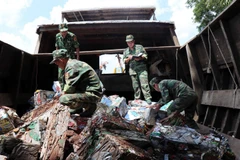 Chiến sỹ Đồn Biên phòng cửa khẩu quốc tế Vĩnh Xương, tỉnh An Giang kiểm tra tang vật vụ vận chuyển phế liệu trái phép qua biên giới. (Ảnh: Xuân Khu/TTXVN)