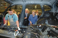 Thủ tướng Đức Angela Merkel (phải) thăm một nhà máy sản xuất xe BMW ở Leipzig, miền Đông Đức. (Ảnh: AFP/TTXVN)