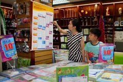 Phụ huynh xem sách giáo khoa tại cửa hàng thuộc hệ thống phân phối chính thức của Nhà xuất bản Giáo dục Việt Nam. (Ảnh: Thanh Tùng/TTXVN)