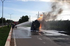 Lực lượng cảnh sát Phòng cháy chữa cháy chữa cháy xe bồn chở dầu biể kiểm soát AX-1026 tại hiện trường. (Ảnh: TTXVN phát)