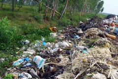 Lượng rác quá tải, chất thành từng đống tràn xuống cả kênh mương nước thủy lợi gây tắc nguồn nước và tràn ra đồng ruộng xung quanh. (Ảnh: Tá Chuyên/TTXVN)