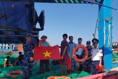 Tặng cờ Tổ quốc cho ngư dân. (Ảnh: Trần Tĩnh/TTXVN)