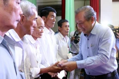 Phó Thủ tướng Thường trực Trương Hòa Bình trao quà cho các gia đình chính sách. (Ảnh: Trần Thị Thu Hiền/TTXVN)