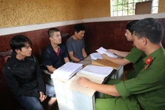 Các đối tượng cá độ tại cơ quan điều tra. Ảnh do cơ quan công an cung cấp. (Nguồn: TTXVN phát)