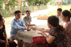 Hỗ trợ các hộ dân xã Mường Giàng có lợn tiêu hủy do dịch bệnh tả lợn châu Phi. (Ảnh: Nguyễn Cường/TTXVN)