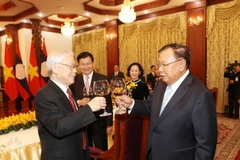 Tổng Bí thư, Chủ tịch nước Lào Bounhang Volachith nâng cốc chúc mừng Tổng Bí thư, Chủ tịch nước Nguyễn Phú Trọng. (Ảnh: Trí Dũng/TTXVN)