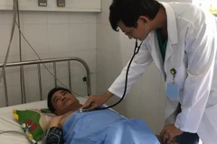 Bác sỹ thăm khám cho bệnh nhân sau can thiệp. (Ảnh: TTXVN phát)