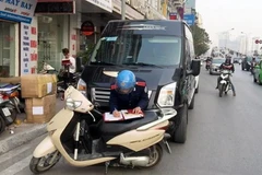 Thanh tra tiến hành lập biên bản xe Limousine dừng đỗ, đón trả khách sai quy định. (Ảnh: Đức Hùng/Vietnam+)