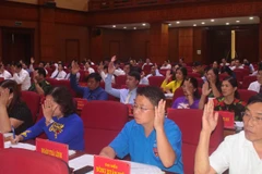 Các đại biểu HĐND tỉnh Cao Bằng biểu quyết thông qua các nghị quyết. (Ảnh: Chu Hiệu/TTXVN)