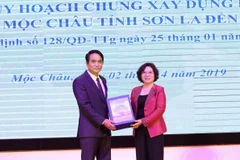 Thứ trưởng Bộ Xây dựng Phan Thị Mỹ Linh trao giao hồ sơ đồ án Quy hoạch chung xây dựng Khu du lịch quốc gia Mộc Châu cho Phó Chủ tịch tỉnh Sơn La Lê Hồng Minh. (Ảnh: Nguyễn Cường/TTXVN)