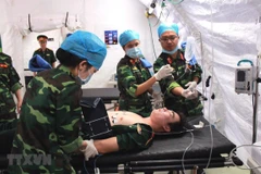 Các cán bộ, sỹ quan Bệnh viện dã chiến cấp 2 diễn tập xử lý tình huống. (Ảnh: Nguyễn Xuân Khu/TTXVN)