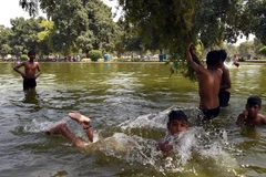 Trẻ em bơi lội để tránh nắng nóng tại New Delhi của Ấn Độ. (Ảnh: THX/TTXVN)