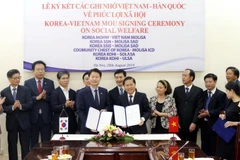 Thứ trưởng Bộ Lao động-Thương binh và Xã hội Lê Tấn Dũng và Thứ trưởng Bộ Y tế và Phúc lợi xã hội Hàn Quốc Ganglip Kim ký kết Bản ghi nhớ hợp tác trong lĩnh vực phúc lợi xã hội. (Ảnh: Anh Tuấn/TTXVN)