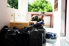 Cán bộ, chiến sỹ Đồn Biên phòng Vĩnh Nguơn kiểm đếm số tang vật vừa thu giữ. (Ảnh: Công Mạo/TTXVN)