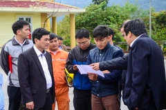 Đoàn công tác xem bản đồ thiết kế khu vực lắp đặt. (Ảnh: Xuân Tư/TTXVN)