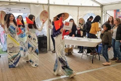 Giới thiệu nón lá, áo dài, trang phục truyền thống của Việt Nam tại Ngày hội Pháp ngữ. (Ảnh: Linh Hương/TTXVN) 