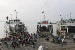 Những hàng khách cuối lên phà Việt Dan 1 - trước khi Bến phà Vàm Cống tạm dừng hoạt động. (Ảnh: Công Mạo/TTXVN) 