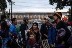 Em bé theo bố mẹ đổ về Tijuana gần biên giới giữa Mexico và Mỹ ngày 15/11/2018. (Nguồn: AFP/TTXVN) 