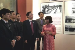 Lãnh đạo thành phố Hà Nội tham quan hình ảnh, hiện vật trưng bày. (Ảnh: Đinh Thuận/TTXVN)