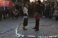 Chàng trai tỏ tình cô gái trong sự reo hò của bạn bè. (Nguồn: QQ)