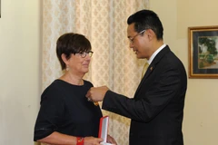 Đại sứ Việt Nam tại Cuba Nguyễn Trung Thành gắn Huân chương Hữu nghị cho bà Jehanne Roccas. (Ảnh: Vũ Lê Hà/TTXVN) 