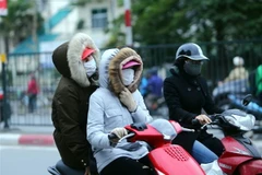 Người dân Hà Nội trang bị áo ấm chống rét, trên đường Giải Phóng. (Ảnh: Danh Lam/TTXVN) 