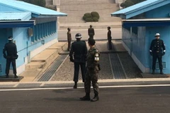 Binh sỹ Hàn Quốc (phía trước) và binh sỹ Triều Tiên (phía xa) gác tại Khu phi quân sự chung (JSA) ở Panmunjom ngày 27/7/2014. (Nguồn: Yonhap/TTXVN) 